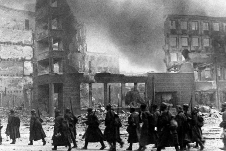 Колонна советских солдат продвигается на новые позиции. Разрушенная площадь Павших борцов в Сталинграде