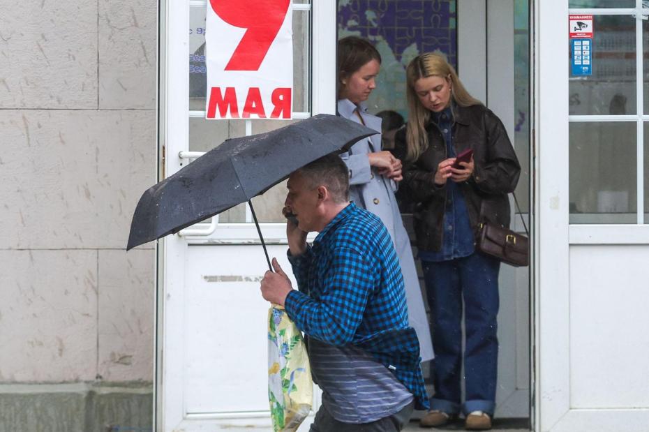 Люди в городе во время весеннего дождя