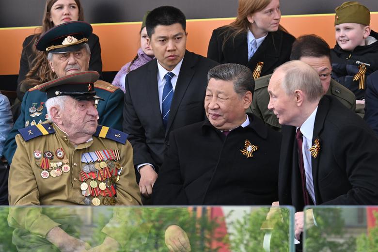 Президент РФ Владимир Путин и председатель КНР Си Цзиньпин общаются с ветераном на Красной площади в Москве на военном параде, посвященном 80-летию Победы