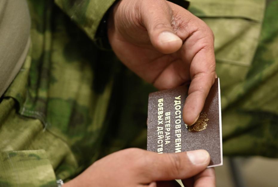 Участник специальной военной операции держит удостоверение ветерана боевых действий