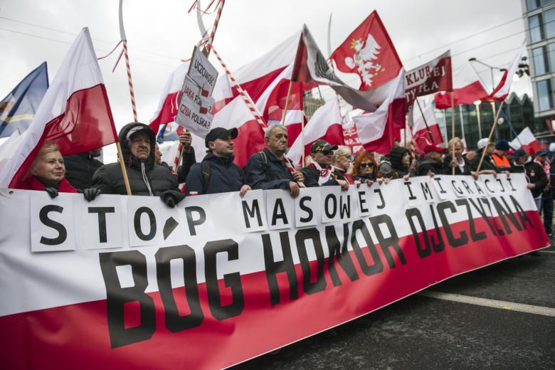 Протестующие держат баннер с надписями «Остановите массовую миграцию» и «Бог, честь, отечество»