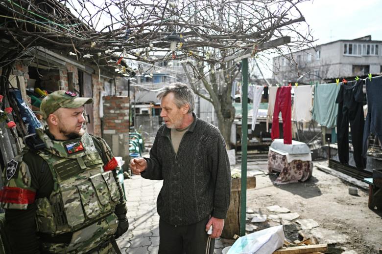 Мужчина во дворе своего дома в Судже общается с военнослужащим РФ