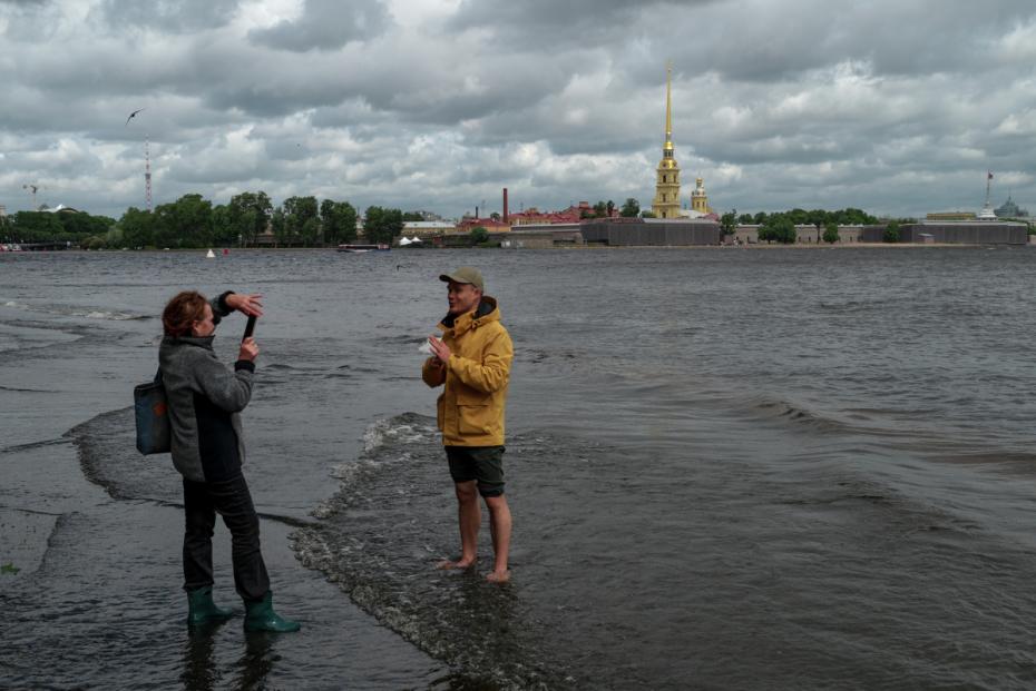 Горожане наблюдают подъем уровня воды в реке Неве. Сильный ветер и дождь начались в городе вечером 3 июля. Затворы комплекса защитных сооружений Петербурга закрыли для предотвращения морского нагонного наводнения