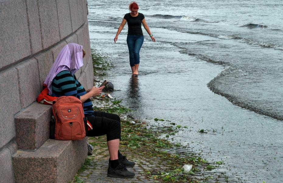 Горожане наблюдают подъем уровня воды в реке Неве. Сильный ветер и дождь начались в городе вечером 3 июля. Затворы комплекса защитных сооружений Петербурга закрыли для предотвращения морского нагонного наводнения