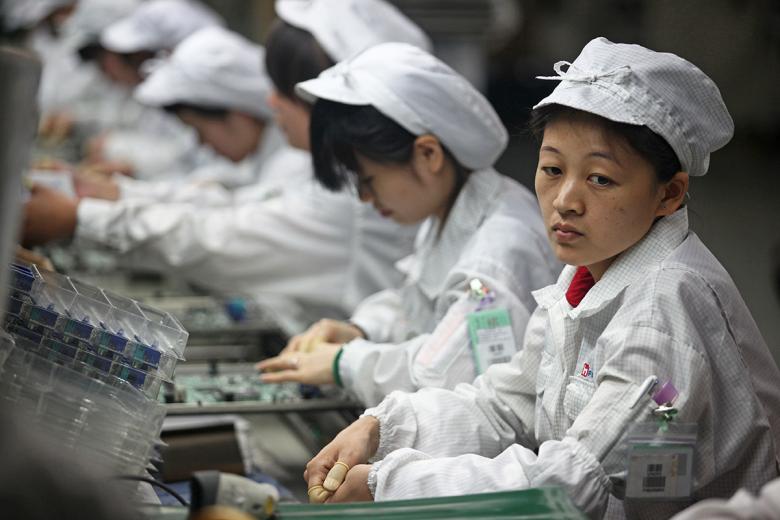 Рабочие на заводе, который производит технику Apple в Китае