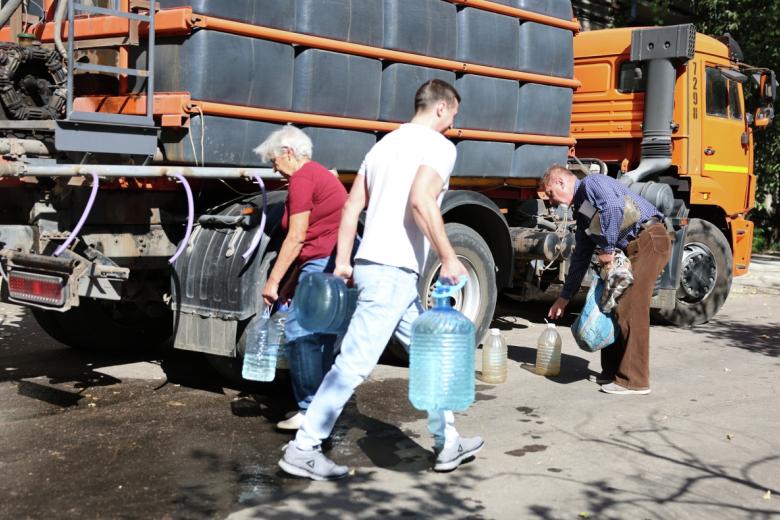 Люди набирают техническую воду для бытовых нужд из водовоза на улице в Донецке