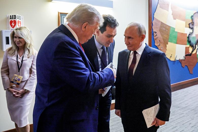 Президент России Владимир Путин и президент США Дональд Трамп (справа налево) после совместной пресс-конференции по итогам переговоров на Аляске