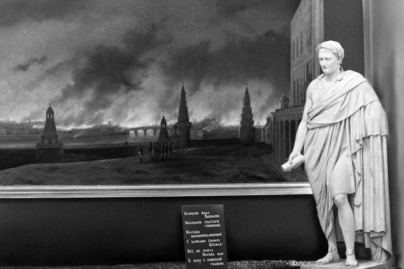 Статуя Наполеона на фоне картины «Пожар Москвы 1812 года».