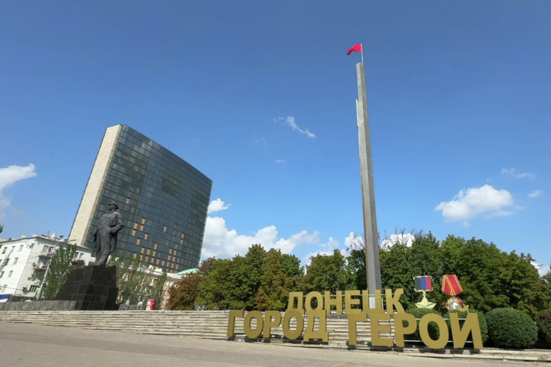 Красное знамя, водруженное над центральной площадью Ленина в Донецке ко Дню освобождения Донбасса от немецко-нацистских захватчиков