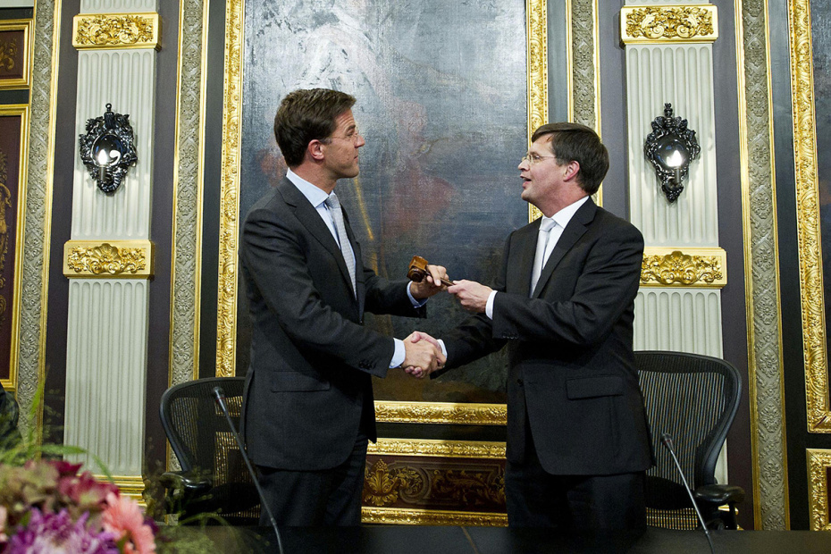 Премьер-министр Нидерландов Марк Рютте (слева) получает молоток от своего предшественника Яна Петера Балкененде во время церемонии в здании парламента Нидерландов, 2010 год