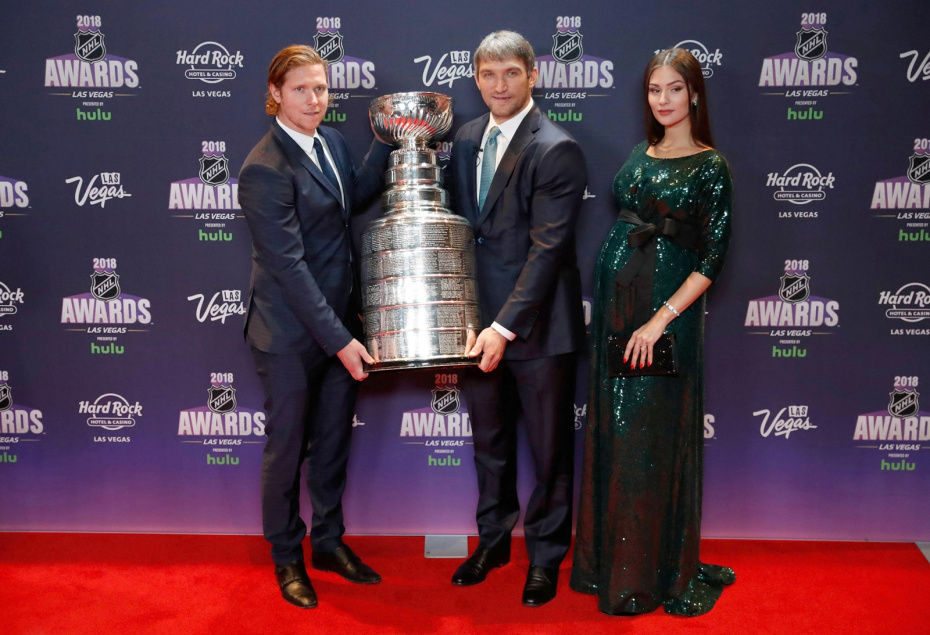 Никлас Бэкстрем из «Вашингтон Кэпиталз» и его товарищ по команде Алекс Овечкин с женой Анастасией Шубской позируют с Кубком Стэнли на красной дорожке во время церемонии вручения наград NHL Eishockey Herren USA Awards 2018 от Hulu