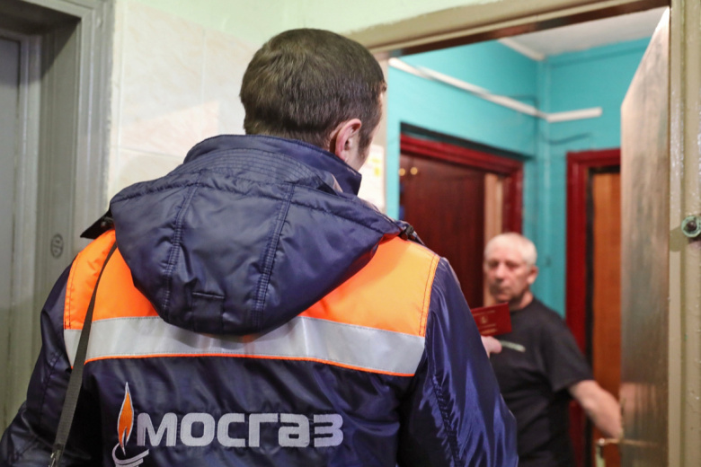 Сотрудник газовой службы показывает служебное удостоверение жильцу квартиры