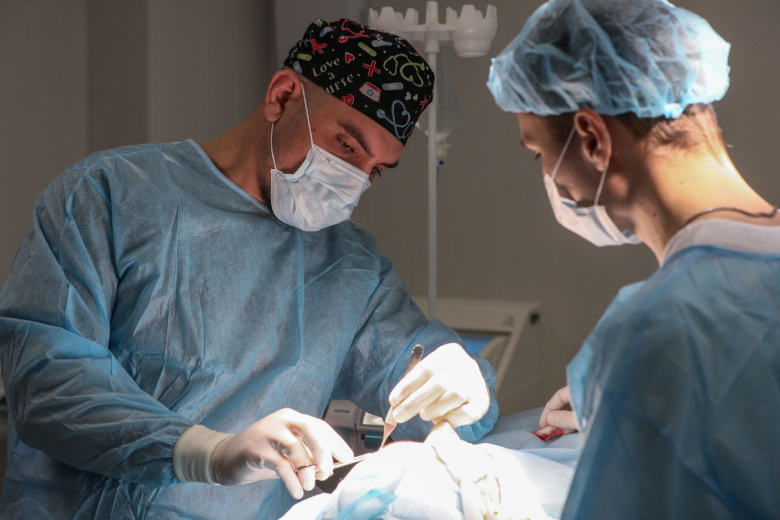Пластические хирурги делают операцию пациенту в клинике