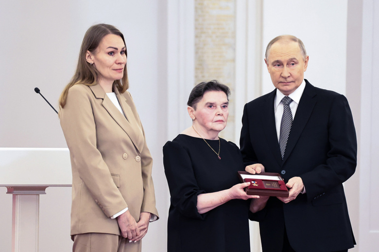 Владимир Путин передает награду его матери Татьяне Афанасьевой и супруге Марине Бородиной