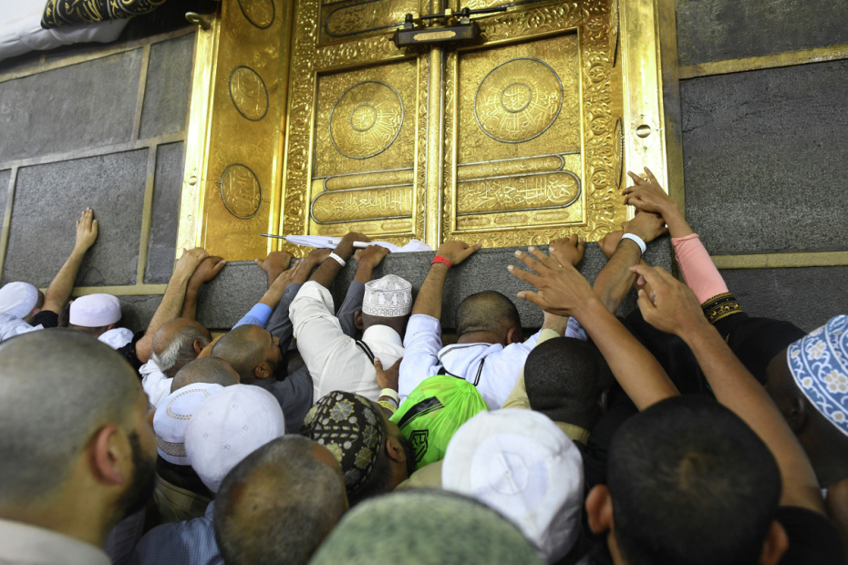Паломник во время хаджа дотрагивается до Каабы во время обхода вокруг нее в мечети Месжид аль-Харам в Мекке