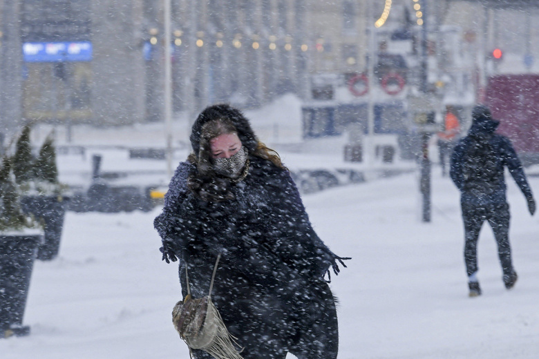 Люди на улице в Хельсинки в ветреную и снежную погоду