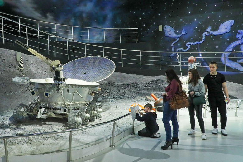 Люди у макета первого лунохода, доставленного на Луну, в Музее космонавтики в Москве