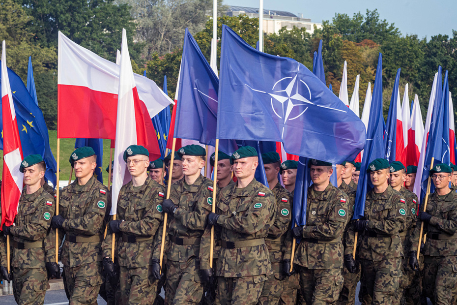 Польские солдаты несут флаги Польши и НАТО