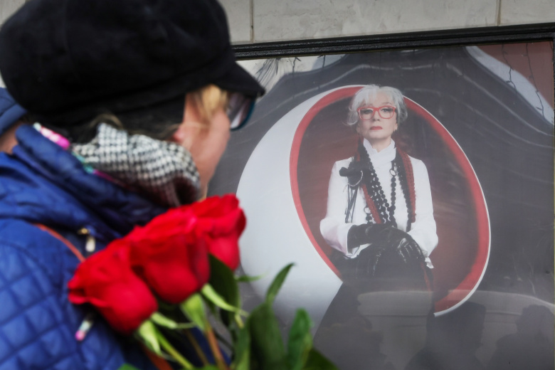 Женщина оставляет цветы у афиши спектакля «Мадам Рубинштейн» в театре имени Пушкина