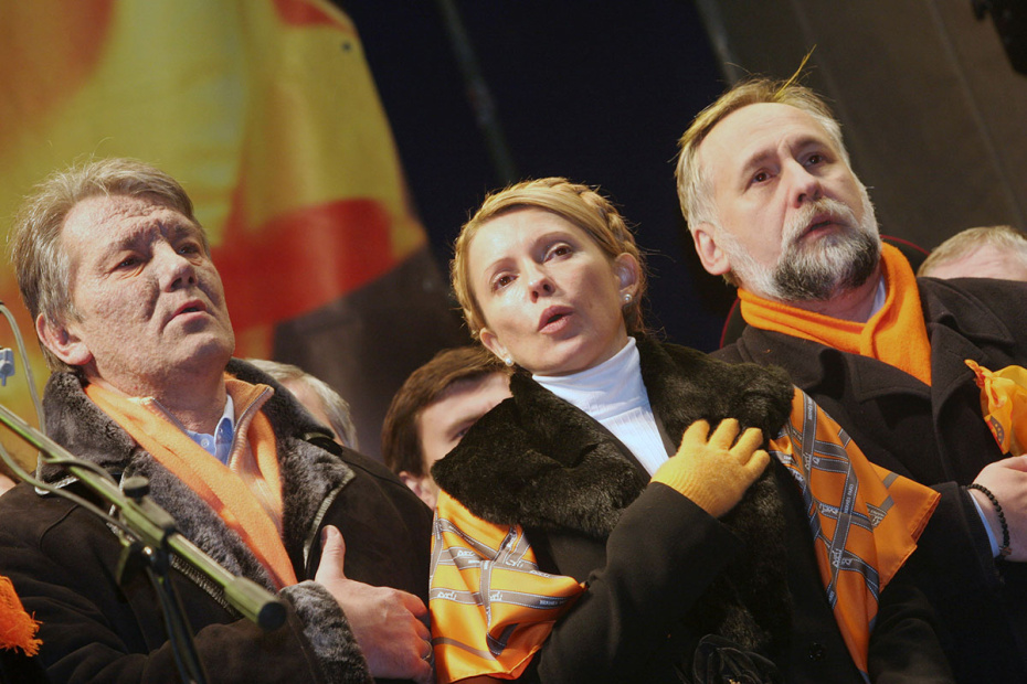 Лидер украинской оппозиции Виктор Ющенко и его главный союзник Юлия Тимошенко (справа) исполняют гимн Украины во время митинга на площади Независимости в центре Киева, 4 декабря 2004 года