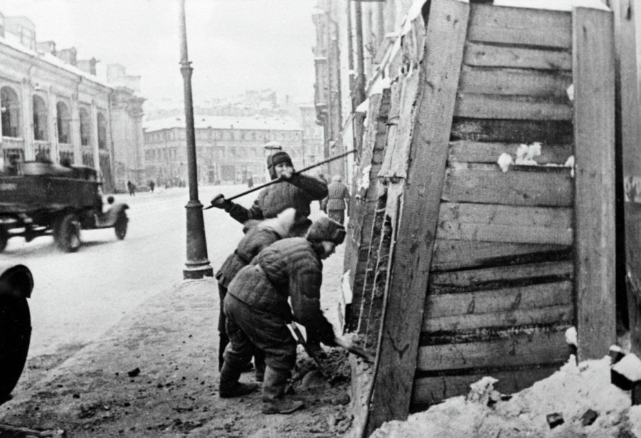 После снятия блокады Ленинграда жители города снимают защитные укрытия с домов на Садовой улице. Слева здание Гостиного двора, 1944 год