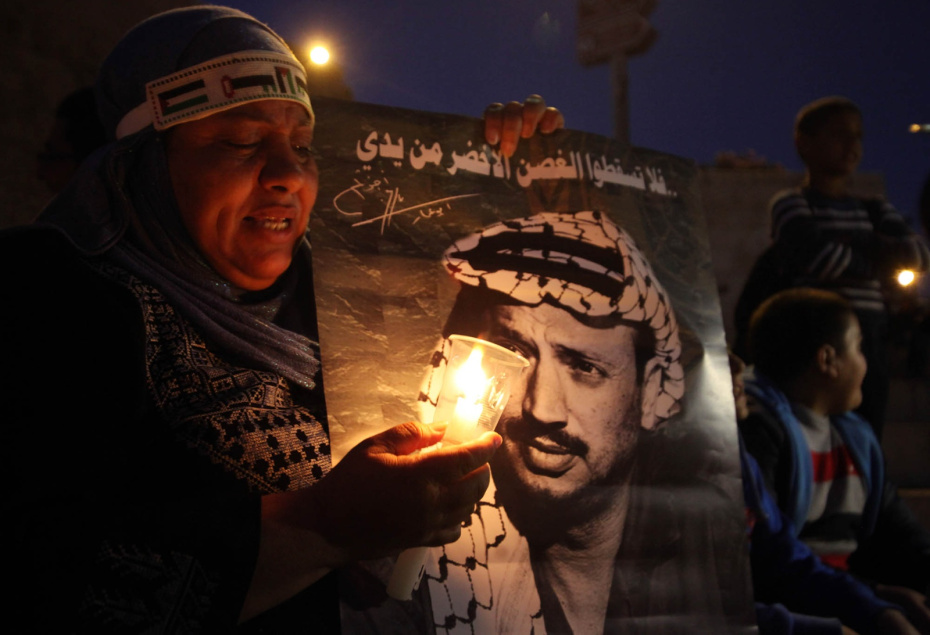 Палестинцы держат плакаты и зажигают свечи, отмечая годовщину смерти палестинского лидера Ясира Арафата, Иерусалим, 2013 год