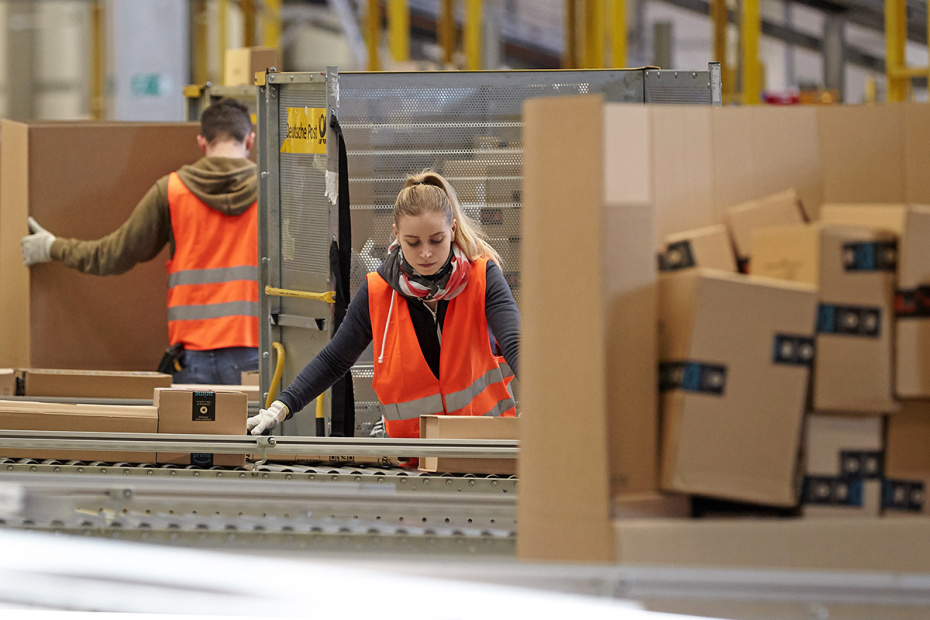 Сотрудники логистического центра Amazon готовят посылки к отправке