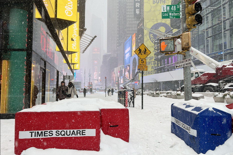 Прохожие прогуливаются по заснеженной Таймс-сквер