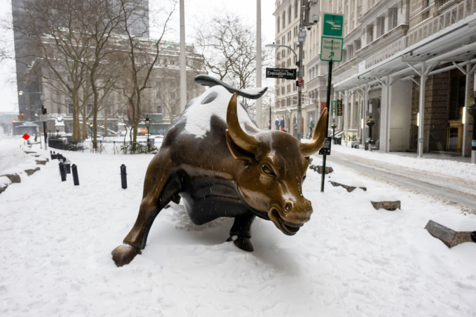 Нью-Йорк, Соединенные Штаты Америки. ‭«Бык с Уолл-стрит» на фоне снегопада в финансовом районе Нью-Йорка