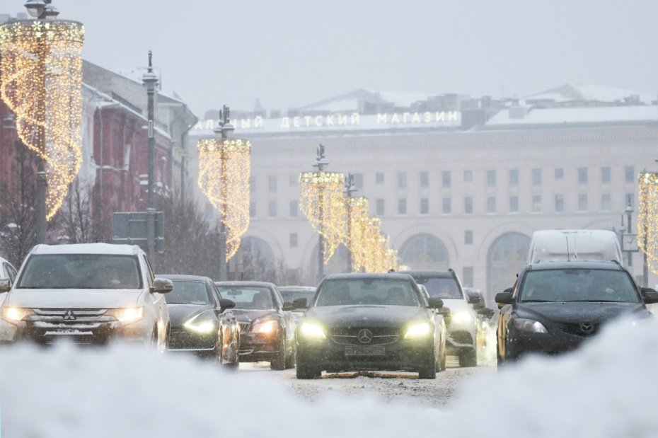 Автомобили на Новой площади во время снегопада в Москве. По словам синоптиков, более трети месячной нормы осадков выпадет в Москве 27 января