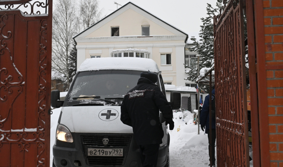 Автомобиль ритуальной службы и сотрудник полиции около здания хостела в Балашихе Московской области, где произошел пожар