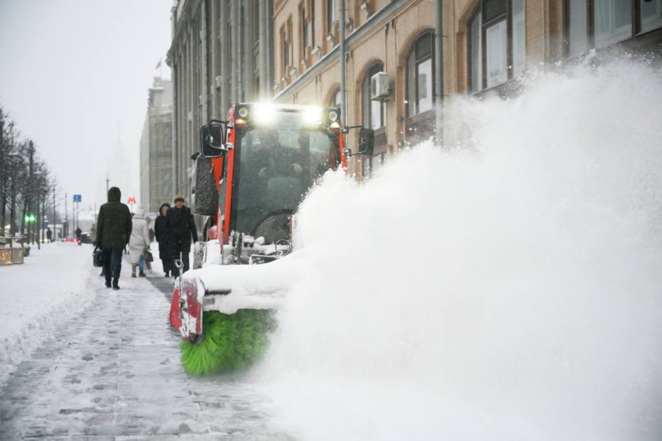 Расчистка тротуара во время снегопада в Москве. По словам синоптиков, более трети месячной нормы осадков выпадет в Москве 27 января