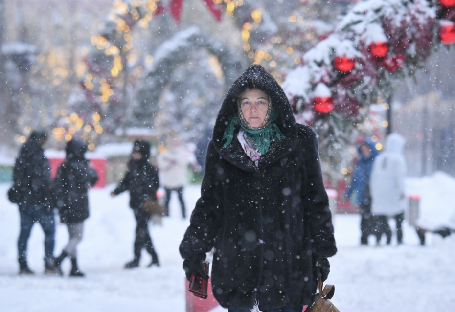 Прохожие во время снегопада в Москве. По словам синоптиков, более трети месячной нормы осадков выпадет в Москве 27 января