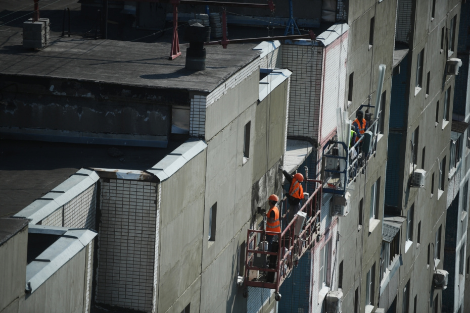 Рабочие проводят ремонт жилого дома