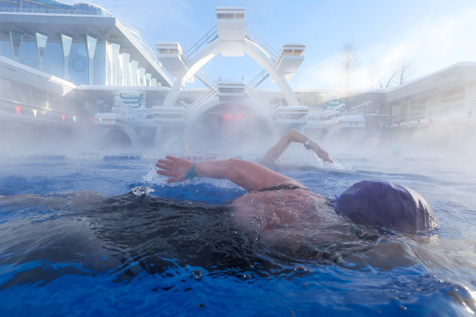 Люди отдыхают в открытом бассейне «Чайка» в морозную погоду