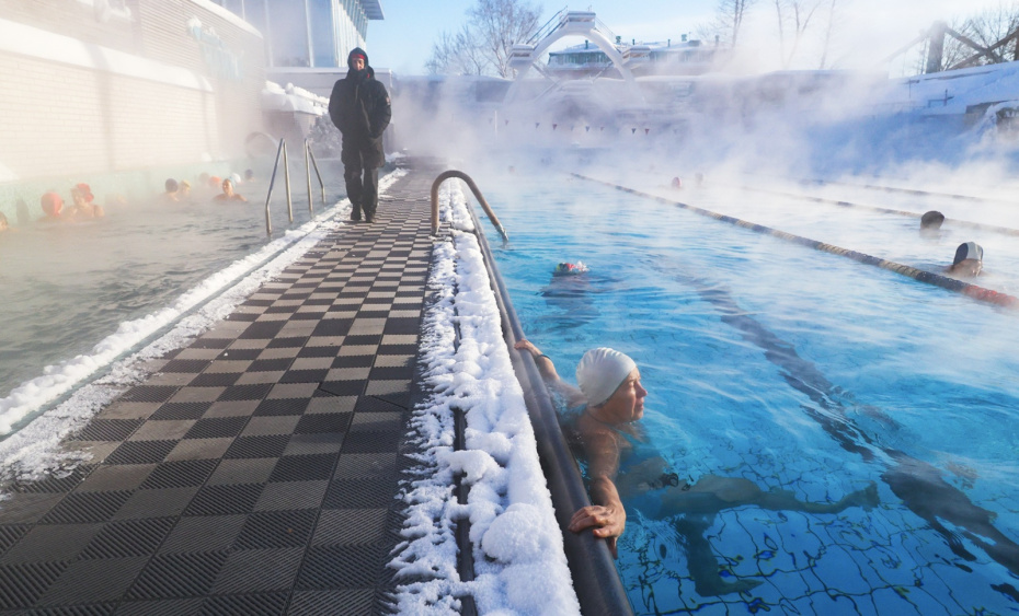 Люди отдыхают в открытом бассейне «Чайка» в морозную погоду