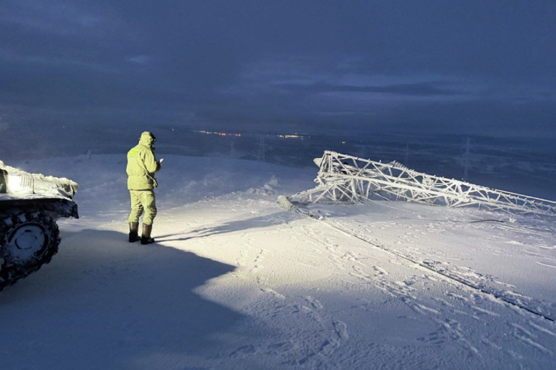 Сотрудник СК РФ у обрушенной опоры линии электропередач (ЛЭП). В Мурманске произошло масштабное отключение электроэнергии из-за повреждения пяти опор ЛЭП, часть районов осталась без света, воды и тепла