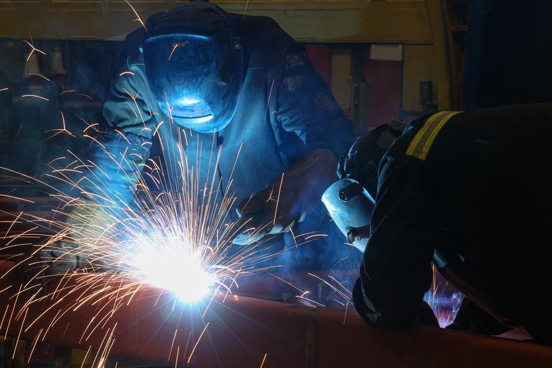 Сварщик в сборочном цехе завода