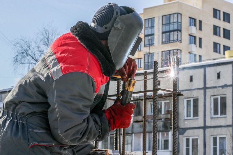 Рабочий занимается сварочными работами в городе