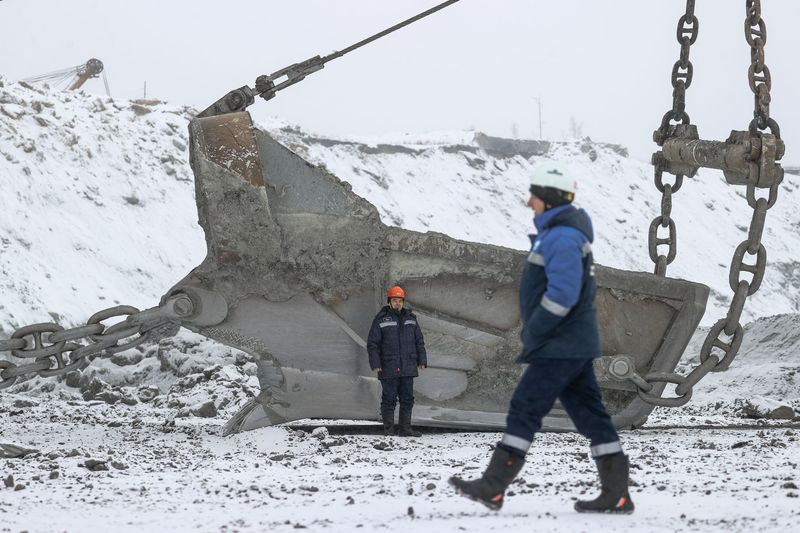 Рабочие стоят у ковша шагающего экскаватора