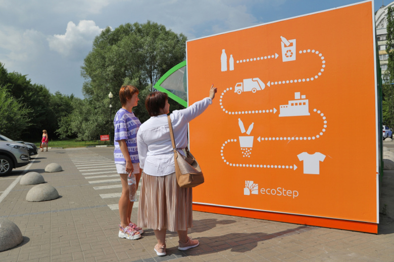 Люди рассматривают схему переработки вторсырья на торце пандомата