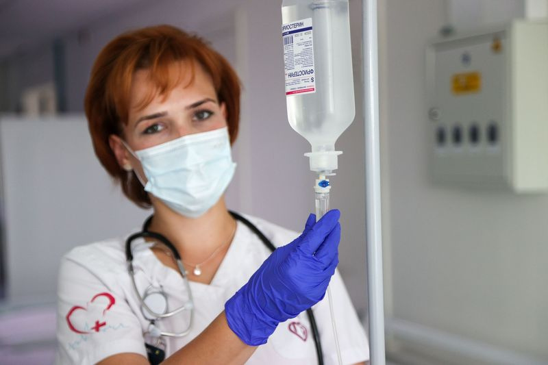 Медицинский работник готовит капельницу в многопрофильном клиническом центре