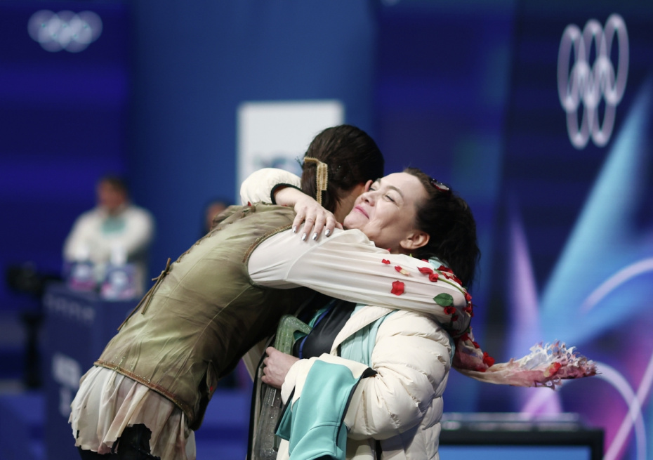 Российский фигурист Петр Гуменник после выступления в нейтральном статусе с короткой программой мужского одиночного катания на XXV зимних Олимпийских играх в Милане. Справа: тренер Петра Гуменника по фигурному катанию Виктория Дайнеко