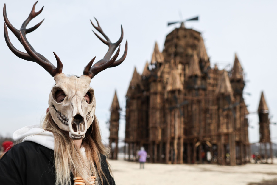 Участник масленичных гуляний у деревянного замка с башнями-мельницами высотой 26 метров в арт-парке «Никола-Ленивец»