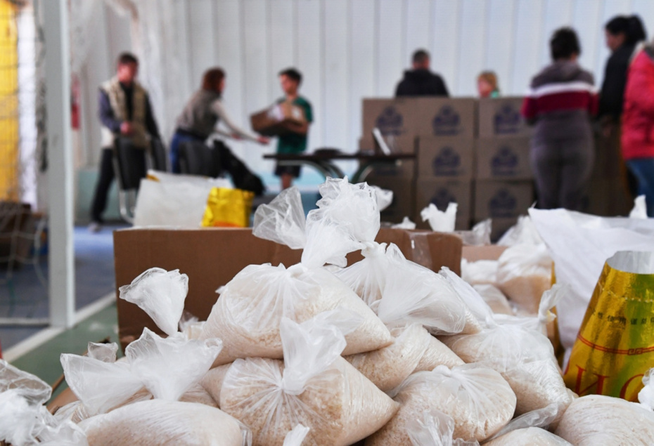 Коробки с рисом в пункте выдачи гуманитарной помощи из России жителям Волчанска Харьковской области