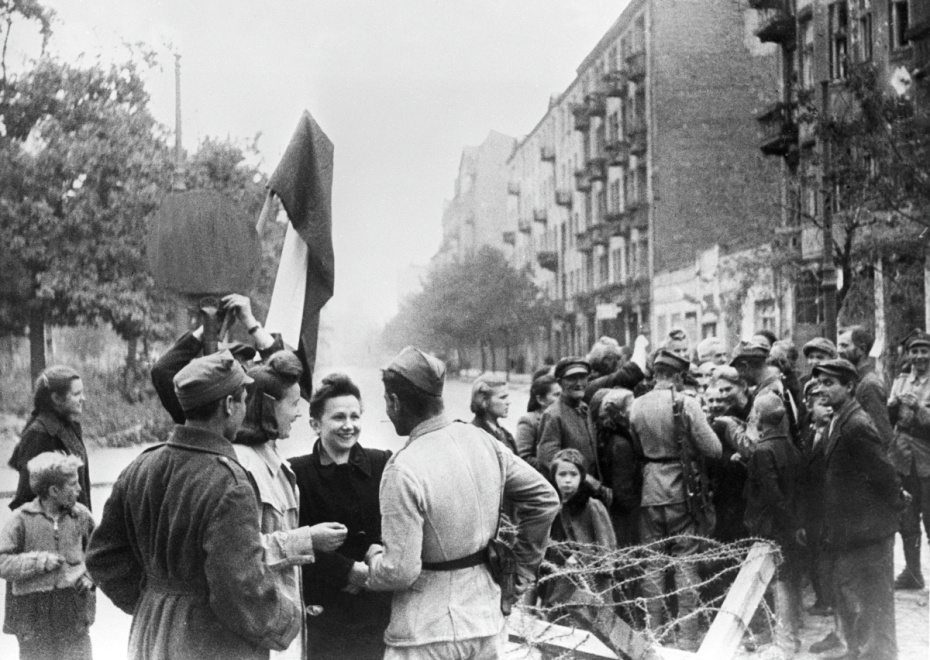 Мирные жители встречают советских солдат и бойцов Армии Крайова на улице в Варшаве, 1944 год
