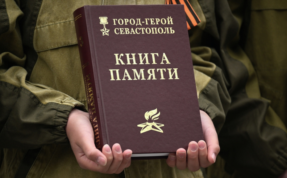 Книга памяти в руках у участника историко-патриотического фестиваля «Знамена Славы» в Севастополе