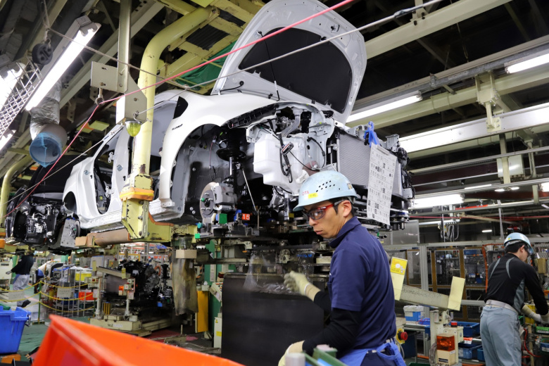 Рабочие японского автомобильного гиганта Toyota Motor собирают двигатель для автомобиля