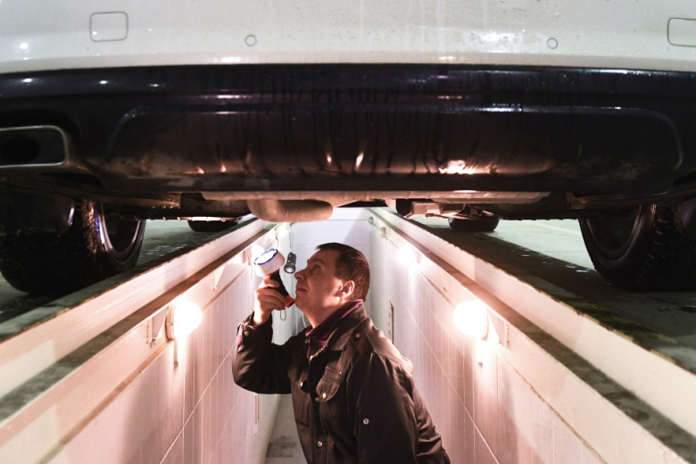 Технический эксперт проводит осмотр автомобиля