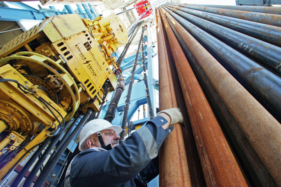 Бурильщик работает с пакетом буровых труб на буровой установке